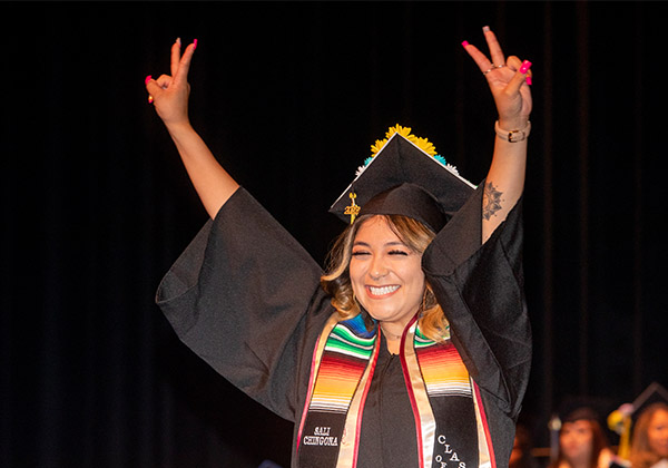 Student at Graduation raising her arms