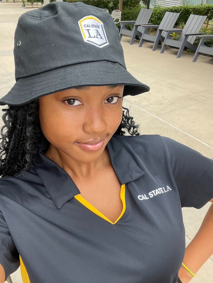 Student in black bucket cap and black polo.