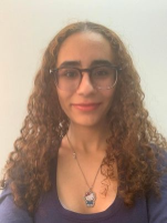 Arwa Hammad wearing a purple top in front of a white background