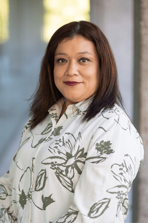 A person with medium length hair smiling.