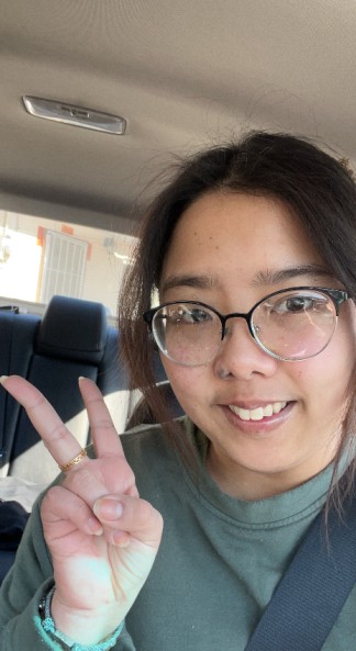 Student in car giving a peace sign.