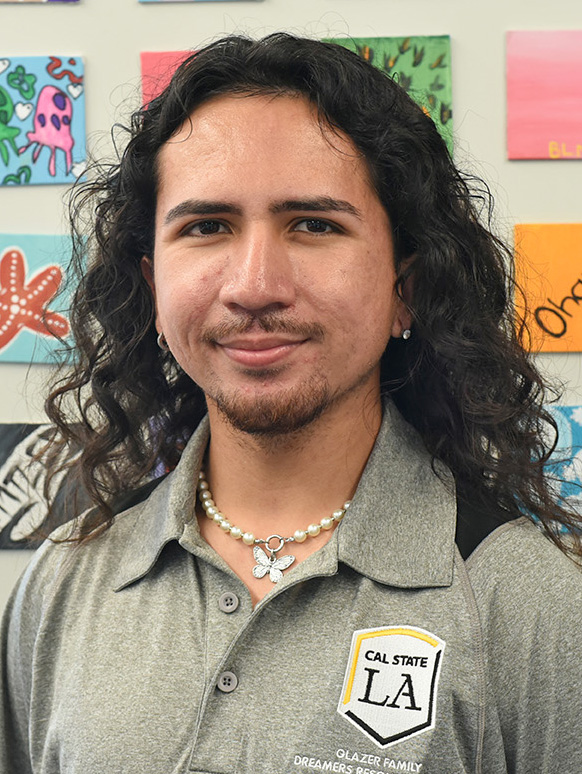 A person with long curly hair smiling