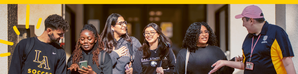 Cal State LA students smiling and laughing in front of the Housing office.