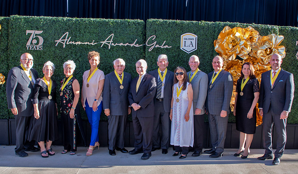 alumni recipients stand with medals