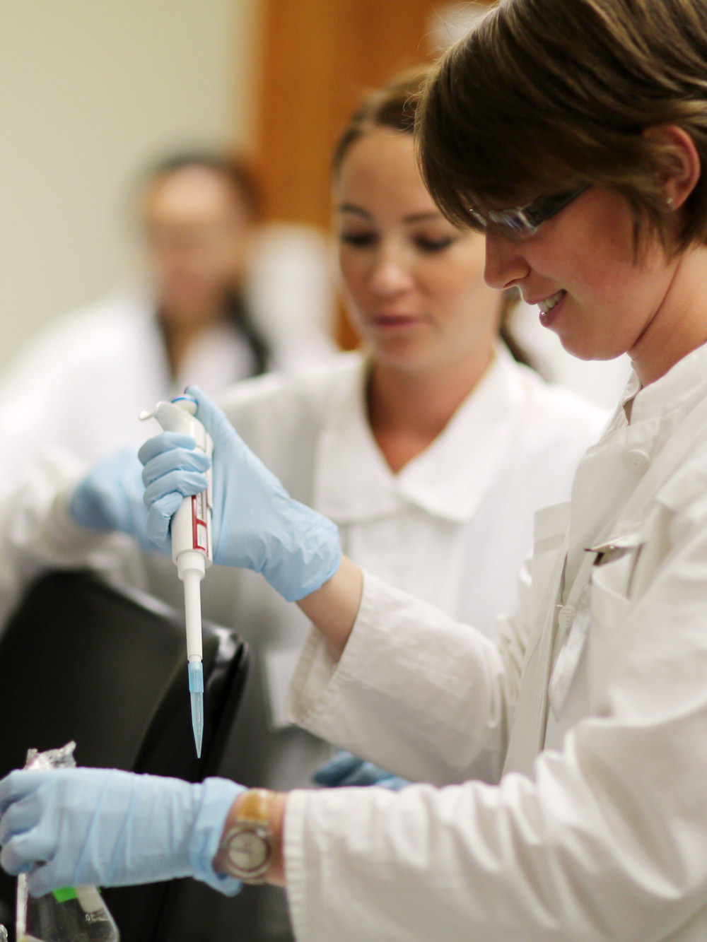 A student using a pipet in a laboratory.