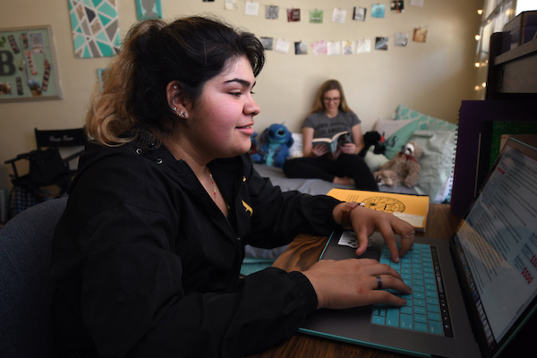 Student typing on a PC in a student dormitory