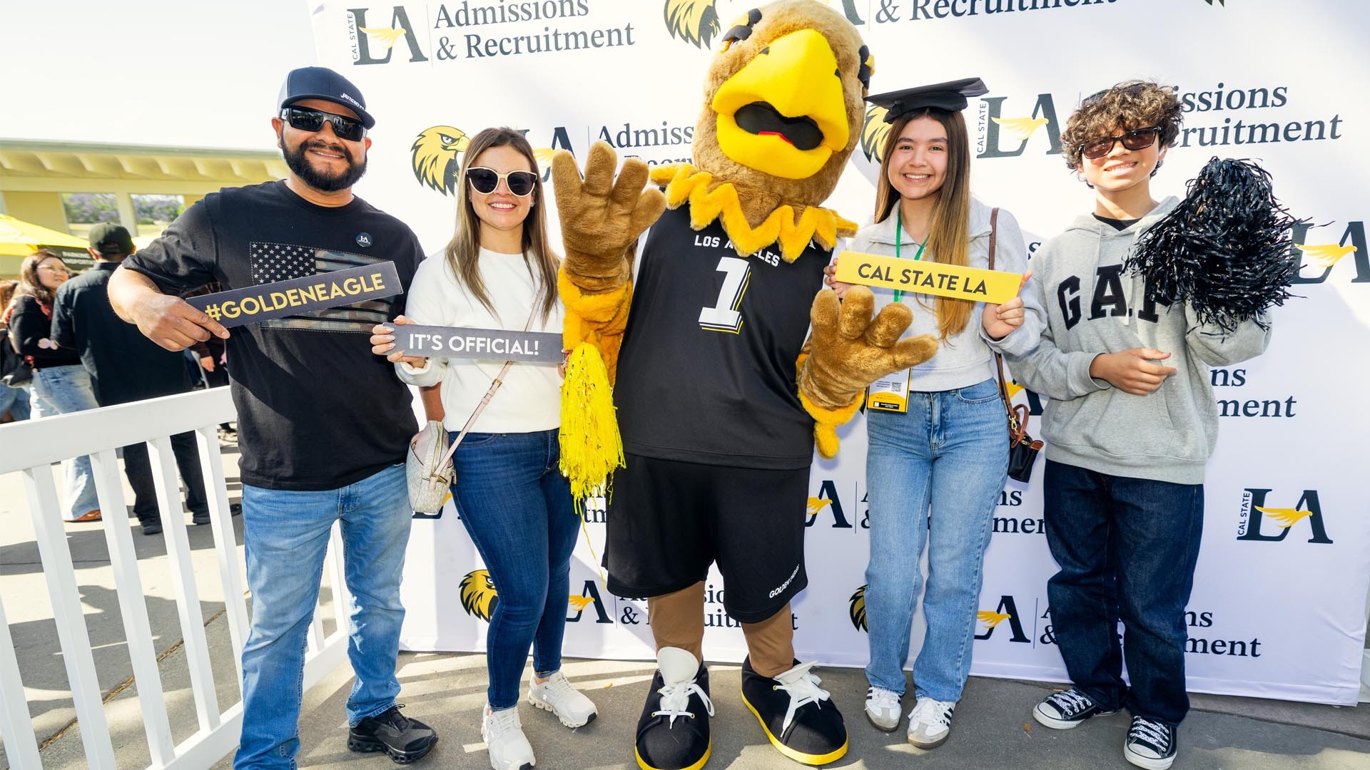 A family takes a group photo with a mascot.