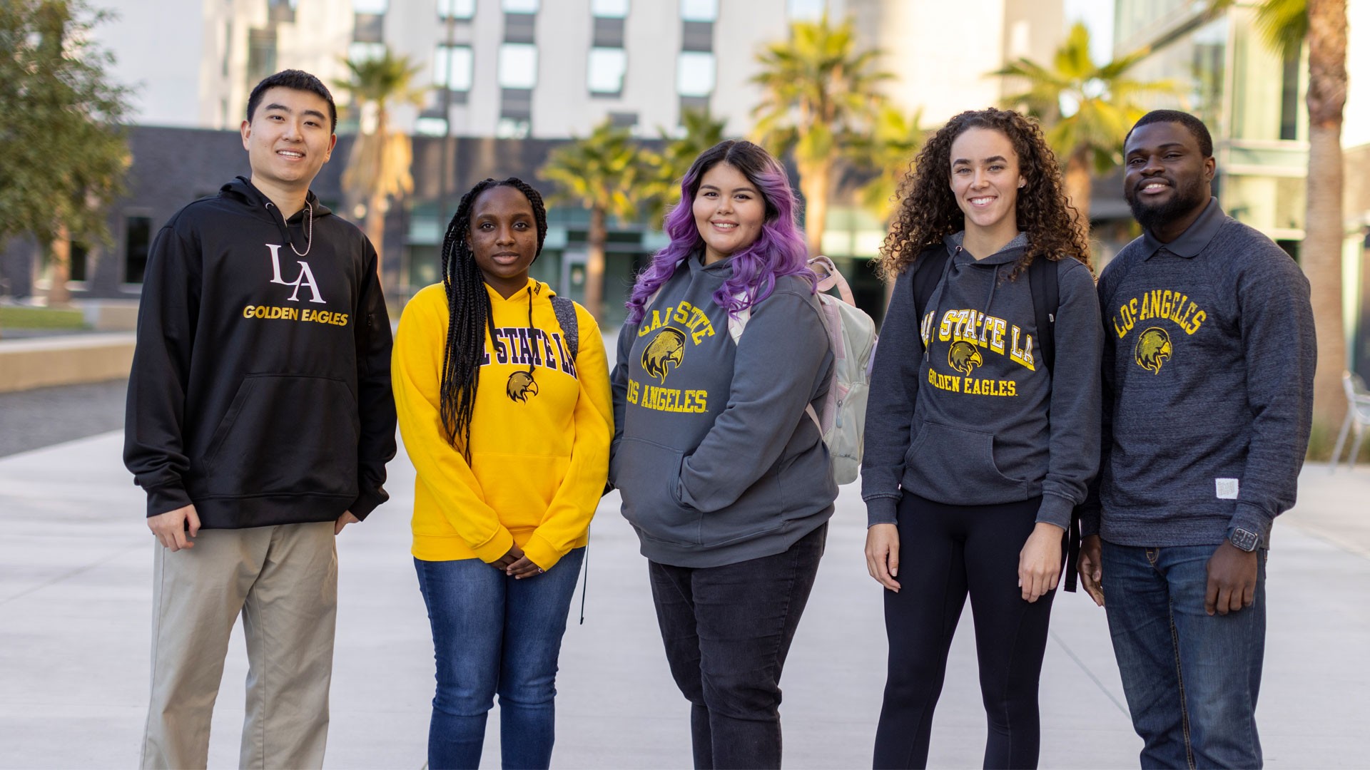 A group of students standing together on a sunny day.