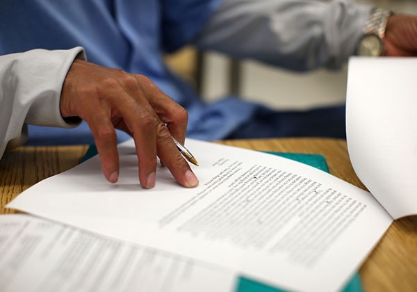 Student's hand on page with text