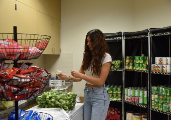 female student at the food pantry, looking at produce