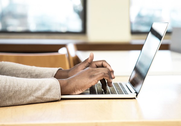 student typing on laptop