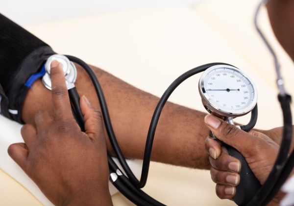 Close-up of a person checking someone's blood pressure.