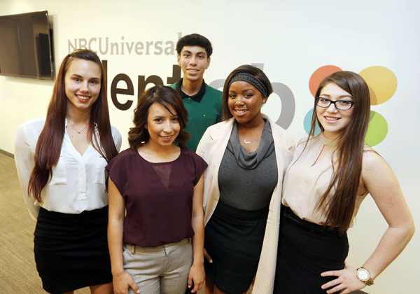 Students smile in professional clothing at company