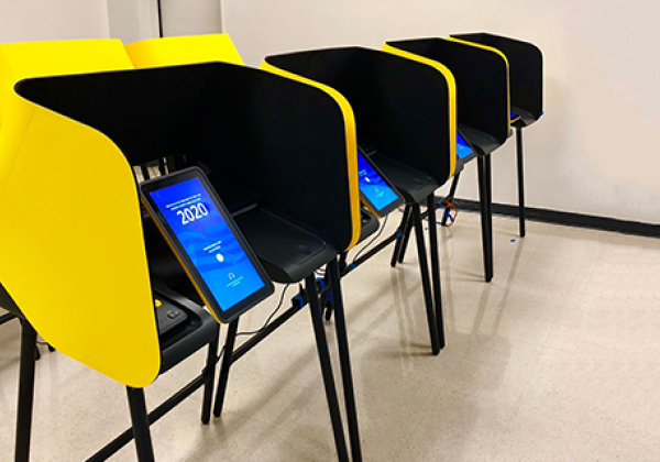 Gold and blue voting machines with a tablet displaying 2020