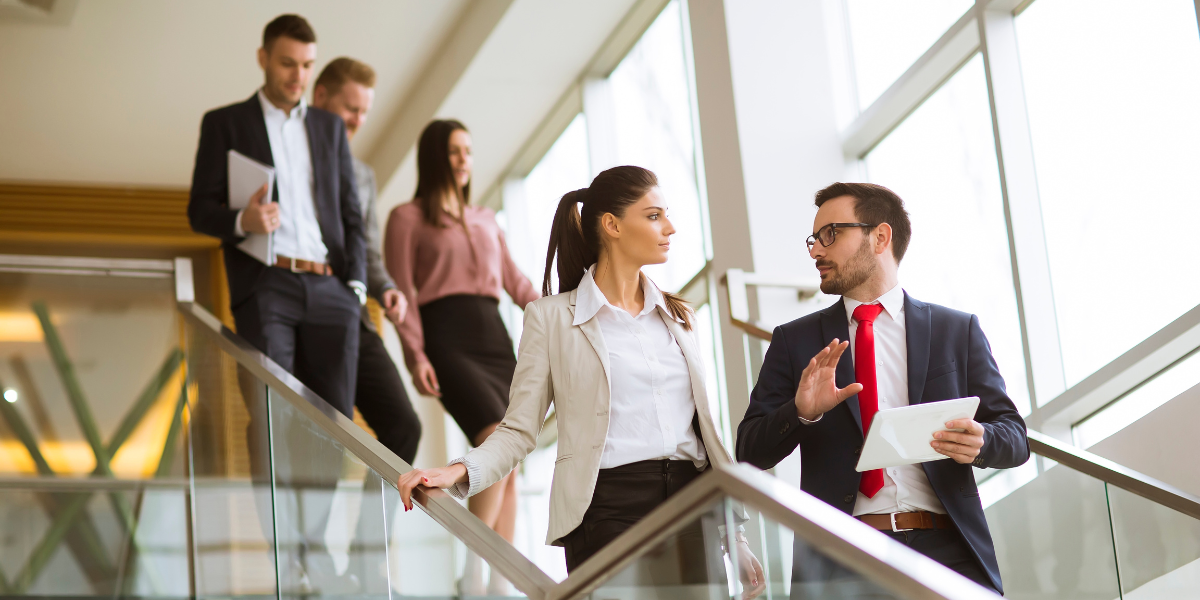 People in office descending staircase