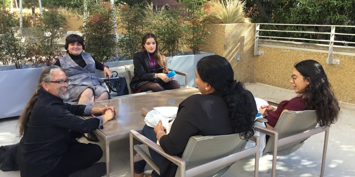 Mellon Mays Undergraduate Fellowship students and instructor sitting across from each other