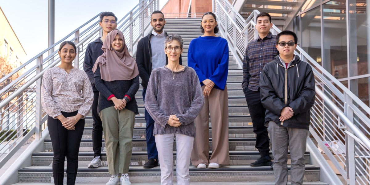 Group of students standing next to professor on an outside stairwell