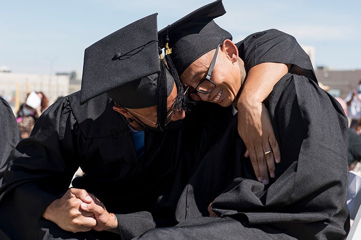 2 prison graduation initiative participants embracing during ceremony