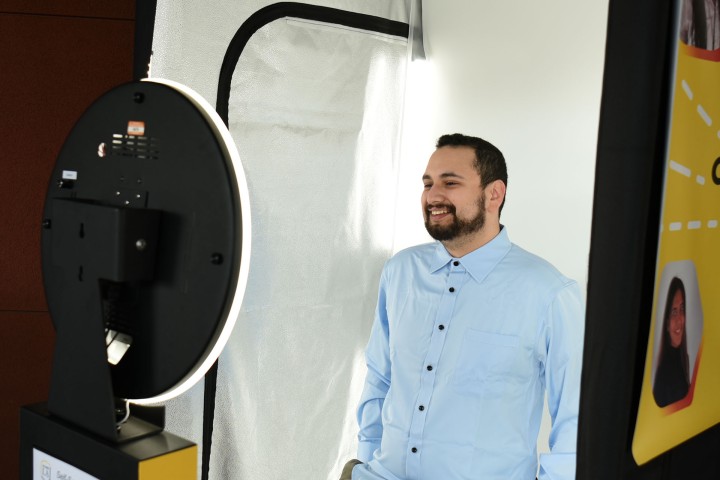 Student smiles confidently while taking professional photo in the Career Photo Booth.