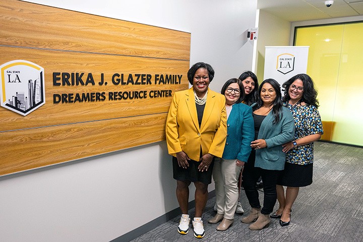 Group of people standing in front of a sign.