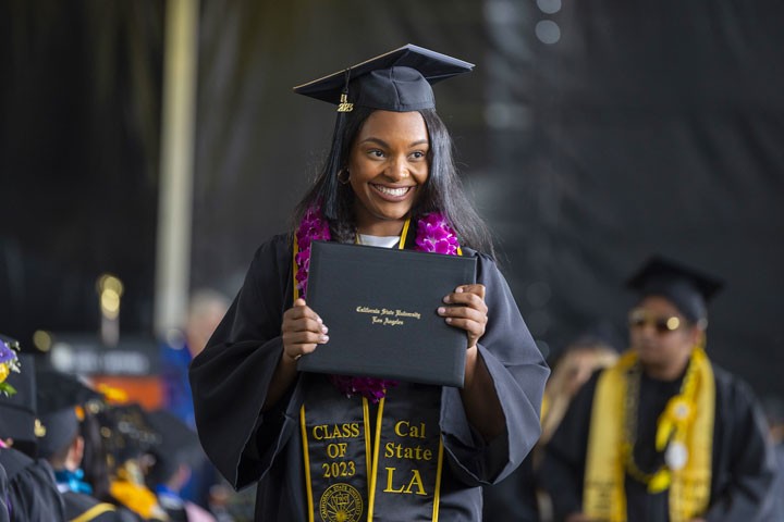 A student holds her diploma at graduation ceremony.