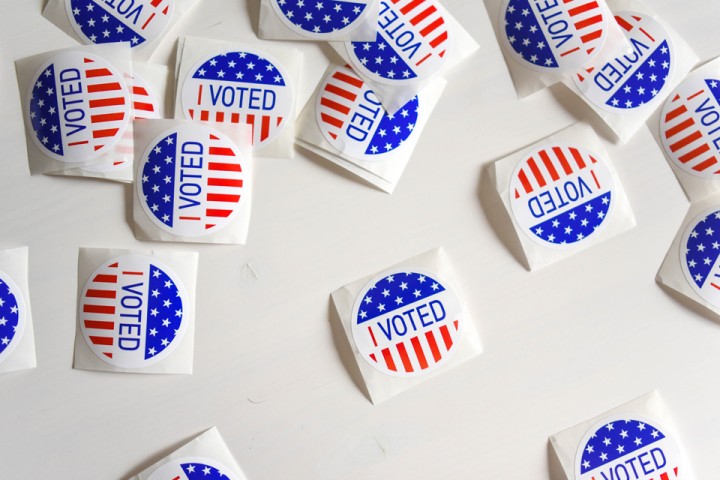 A white table with several "I Voted" stickers on top of it.