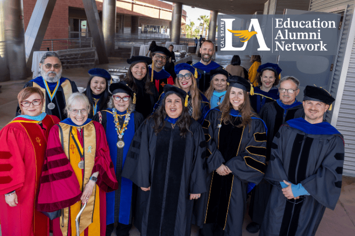 A group of people smiling and posing in doctoral regalia