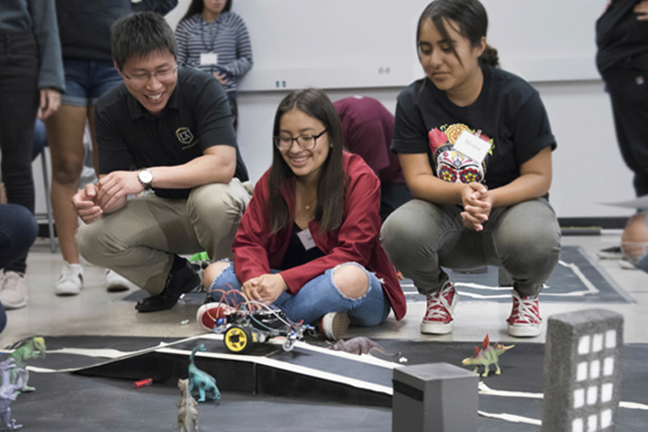 ecst faculty and two girls watch vehicle race on city mockup