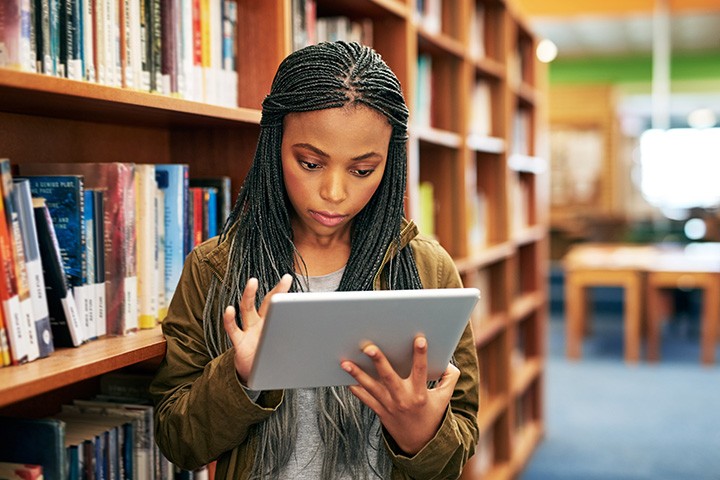 Student looking at an iPad while at the library