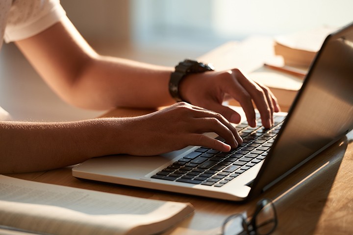 Student typing on laptop