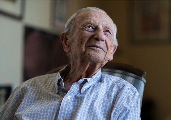 Alumnus Sigmund Burke sitting in chair looking into the distance.