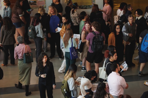 Large number of attendees looking at the different poster boards