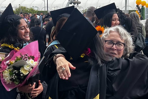 Lia hugging student graduates