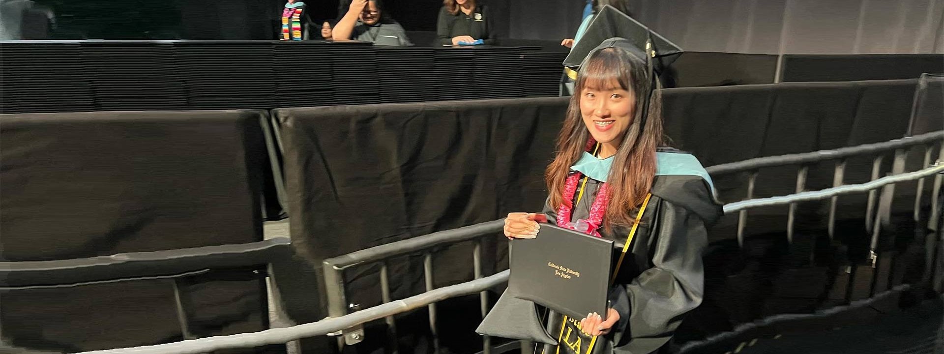 female graduate holding diploma