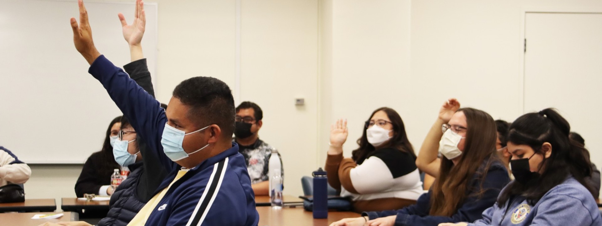 Students raising hands engaged at event